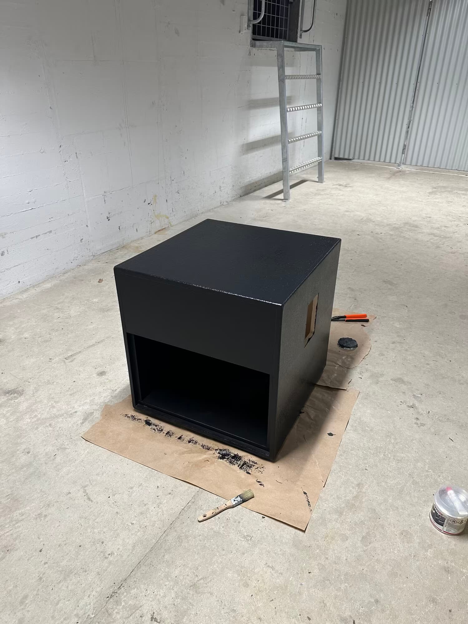 Painted black enclosure standing in the garage